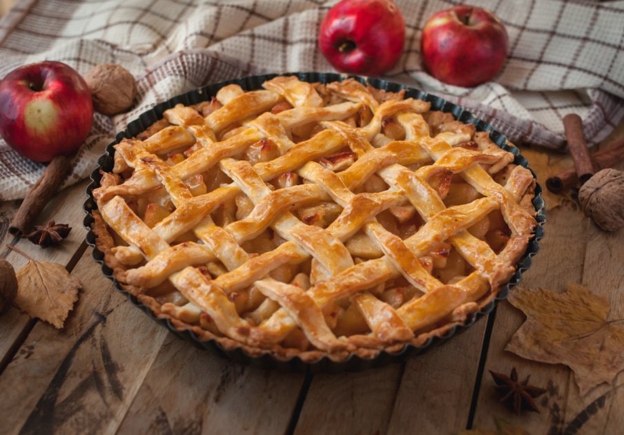 Homemade apple pie on wooden background.