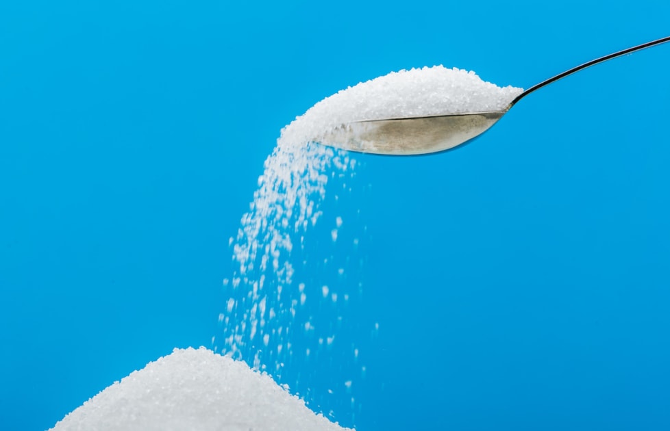 Pouring sugar on a pile of sugar.