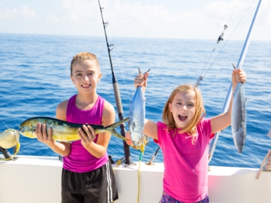 Two girls fishing on a boat.