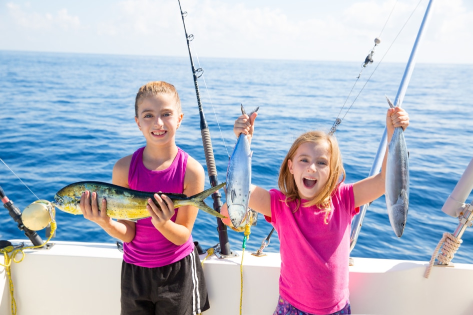 Two girls fishing on a boat.