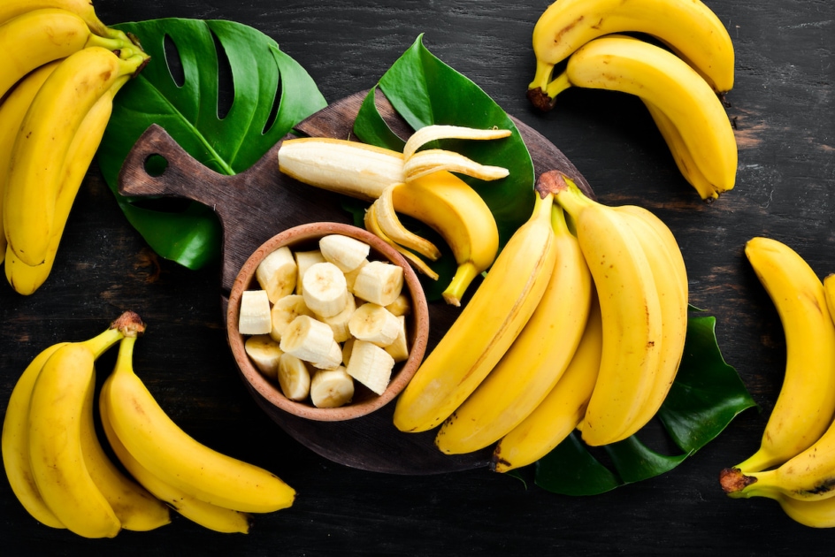 Bananas on a black wooden surface. Tropical Fruits. Top view. Free copy space.