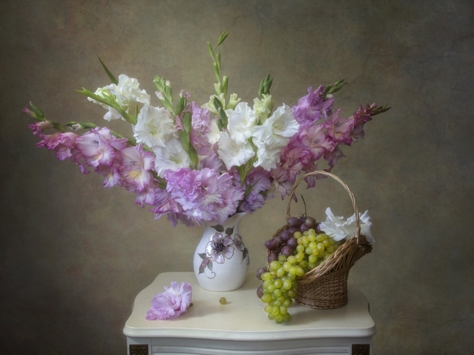 Still life with bouquet of gladiolus flowers in a vase on wooden table