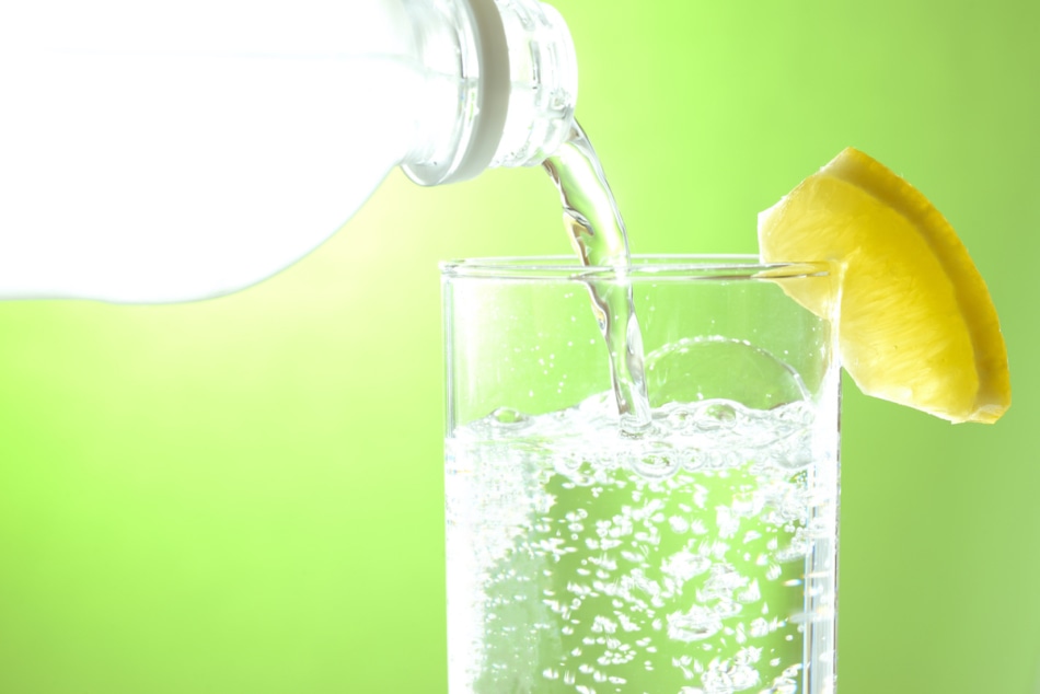 Club soda seltzer in a glass with lemon