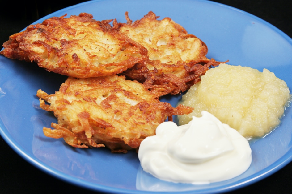 Potato latkes for Hanukkah, served with sour cream and applesauce .