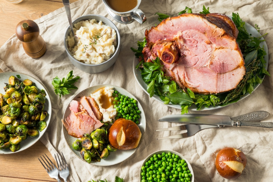 Homemade Glazed Holiday Ham Roast with All the Sides on a table Easter dinner