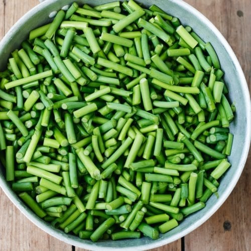 Chopped garlic scapes in a colander.