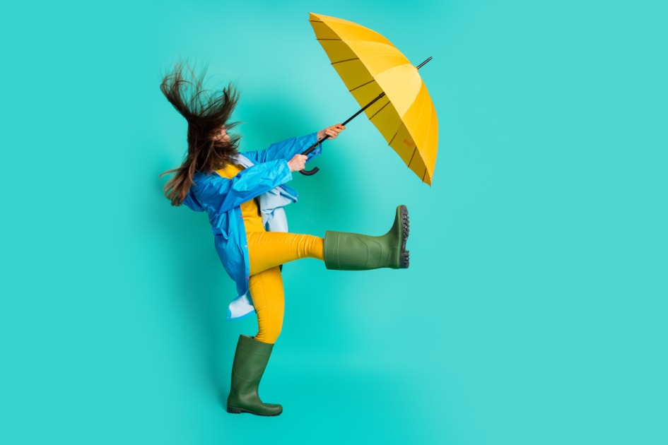 Full length profile photo of shocked lady stormy rainy weather walk, street hold umbrella catch strong wind blew away wear raincoat sweater pants gumboots isolated teal color background.
