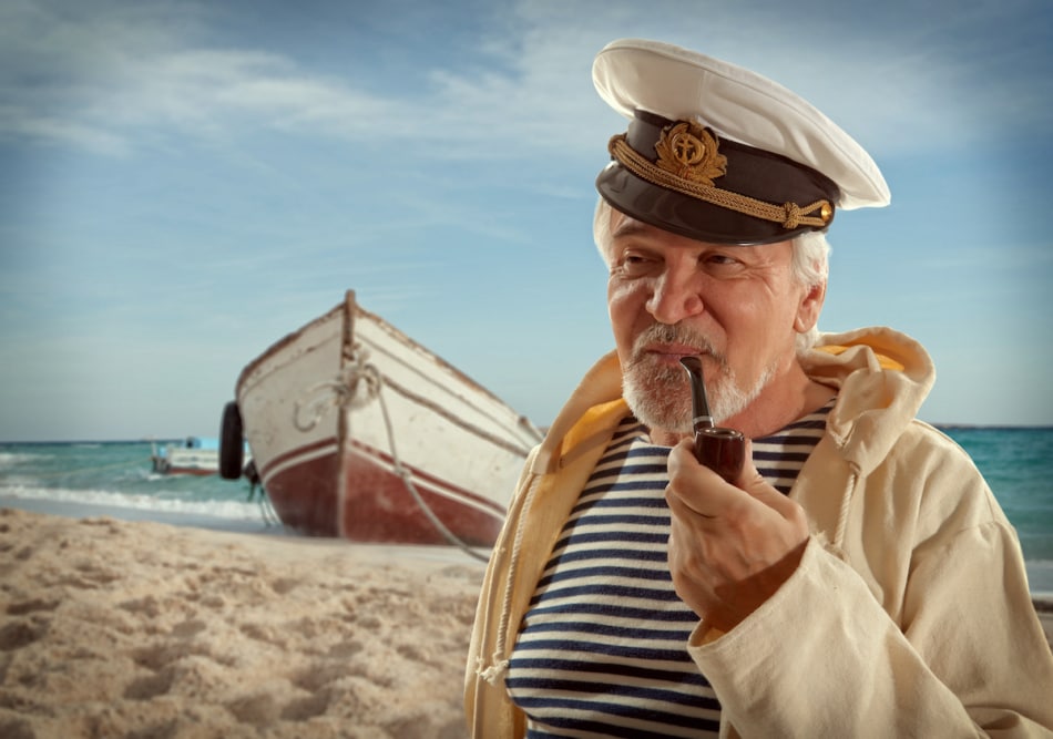 Captain. Sailor man in marina port with boats background.
