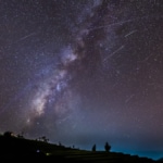 Long time exposure night landscape with the milky way during meteor shower over a mountain with hut.