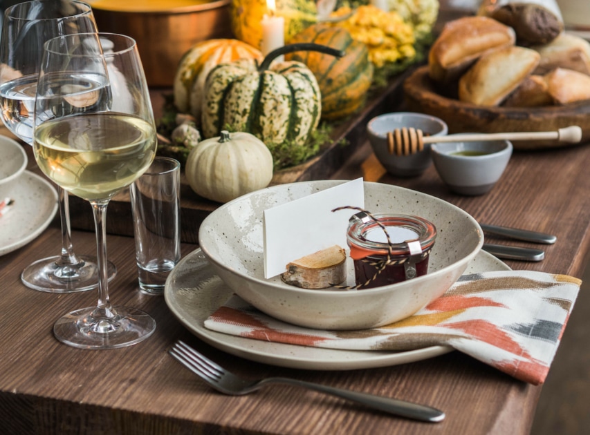 Table setting for Thanksgiving. Autumn table with pumpkins and candles in the center.