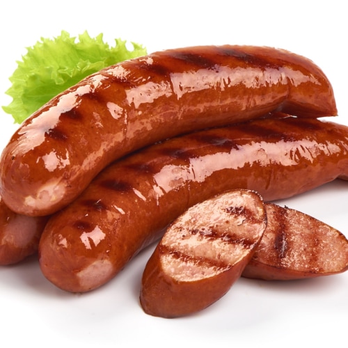 German grilled pork sausages with lettuce, close-up, isolated on white background.