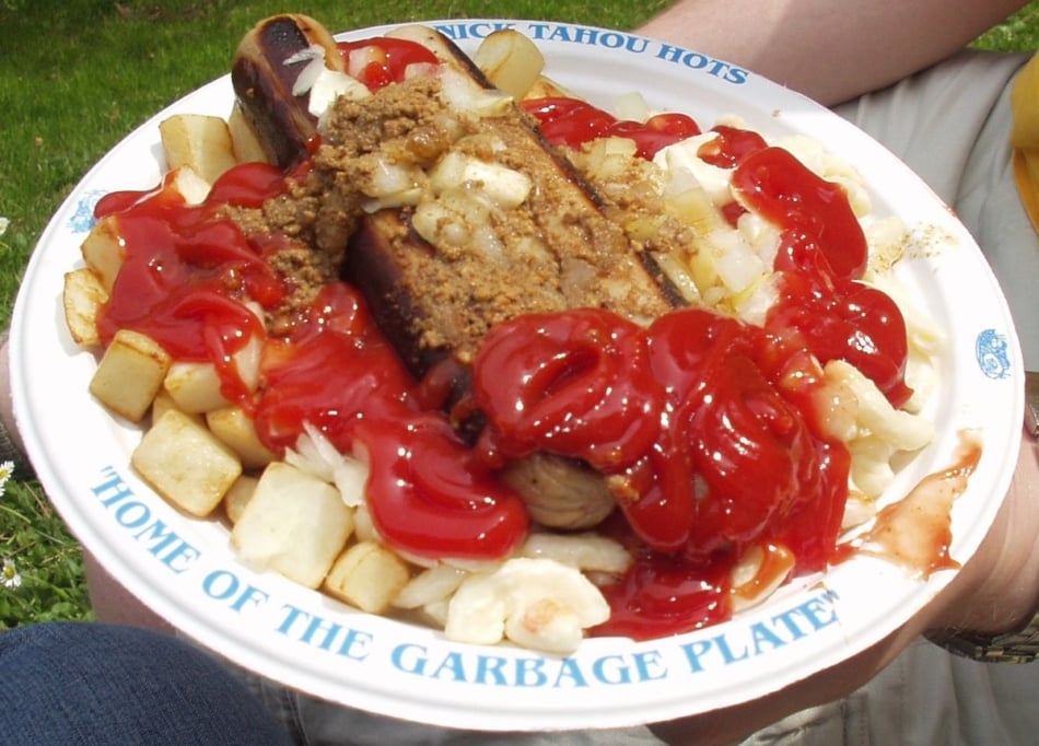 Garbage plate with hot dogs, salads, and ketchup.