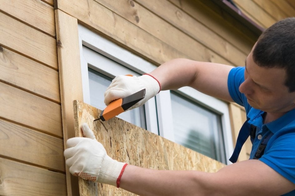 Man blocking the windows before a natural disaster.