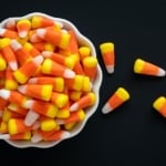 Candy corn overflowing from a white bowl.