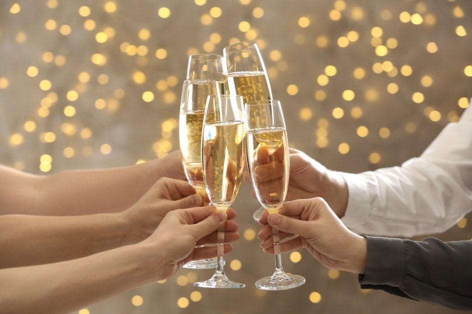 People clinking glasses of champagne on blurred background.