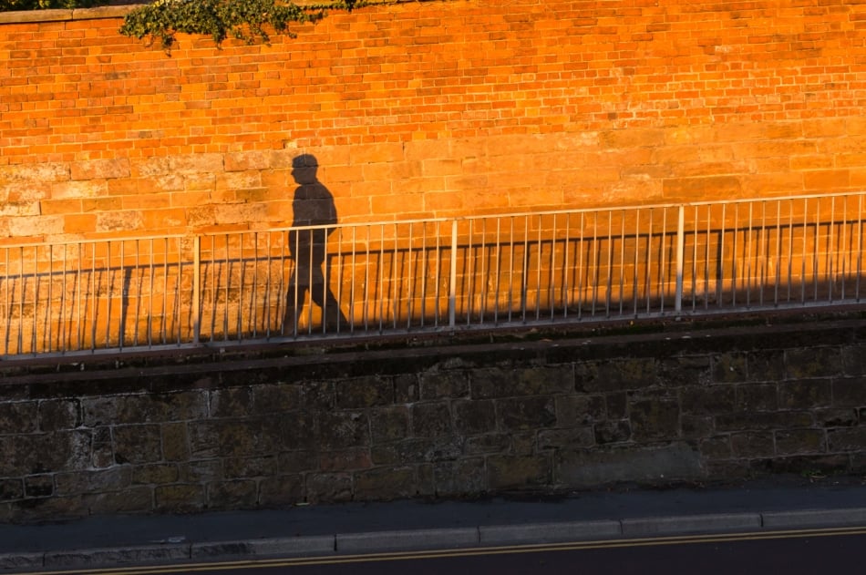 shadow of a person casted on a orange wall