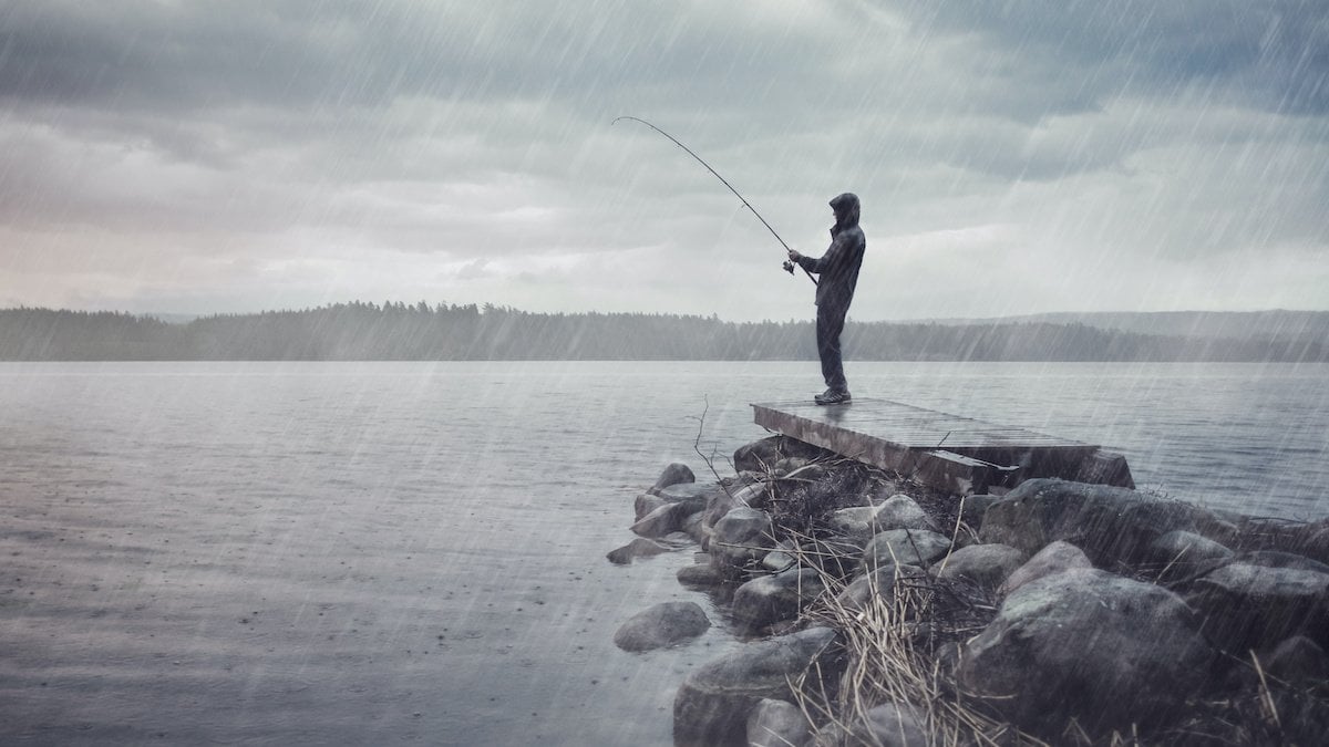 Man fishing in the rain.