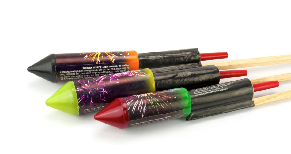 Three fireworks rockets against a white background.