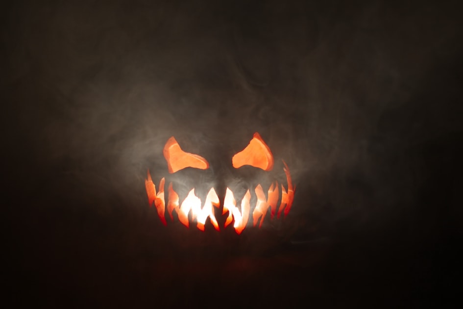 Scary Halloween jack o lantern face glowing in smoke.