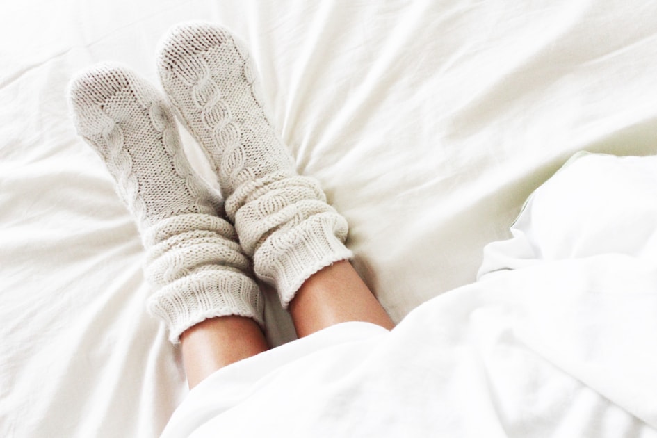 Warm and cozy white socks in the bed.