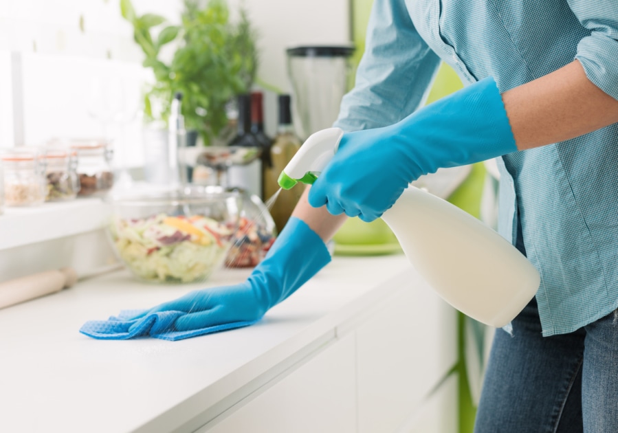 Woman cleaning with a spray detergent.