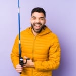 Man in yellow jacket with fishing rod.