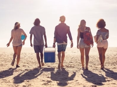 Beachgoers facing sun with shadows behind them.