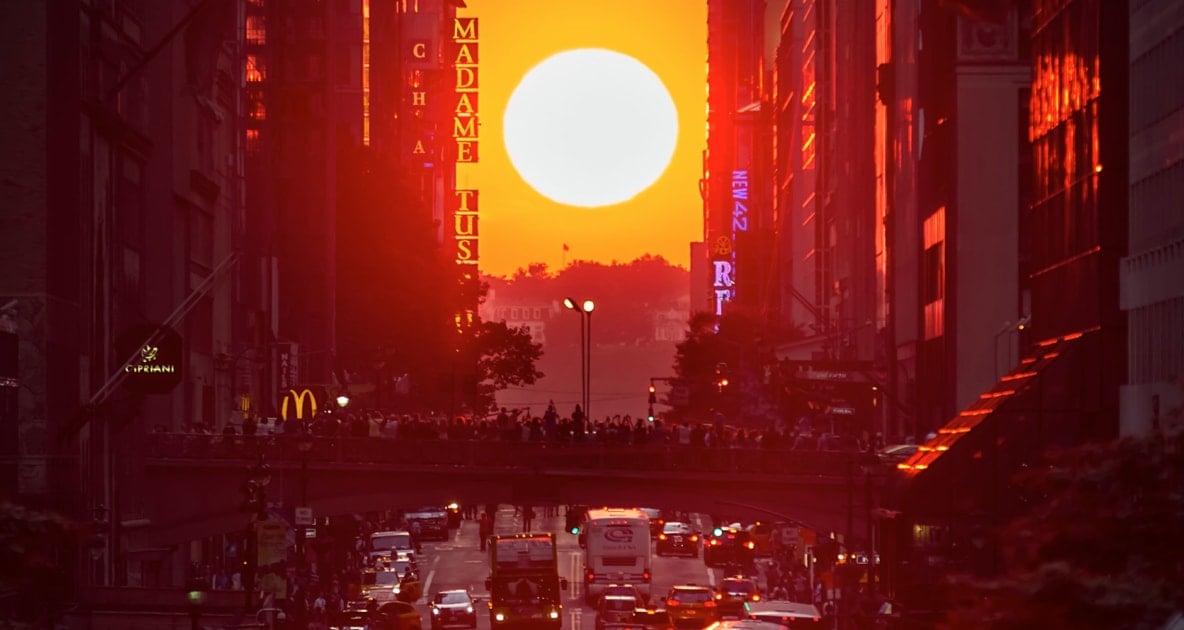 Sun appearing over city block in New York City, known as Manhattanhenge.