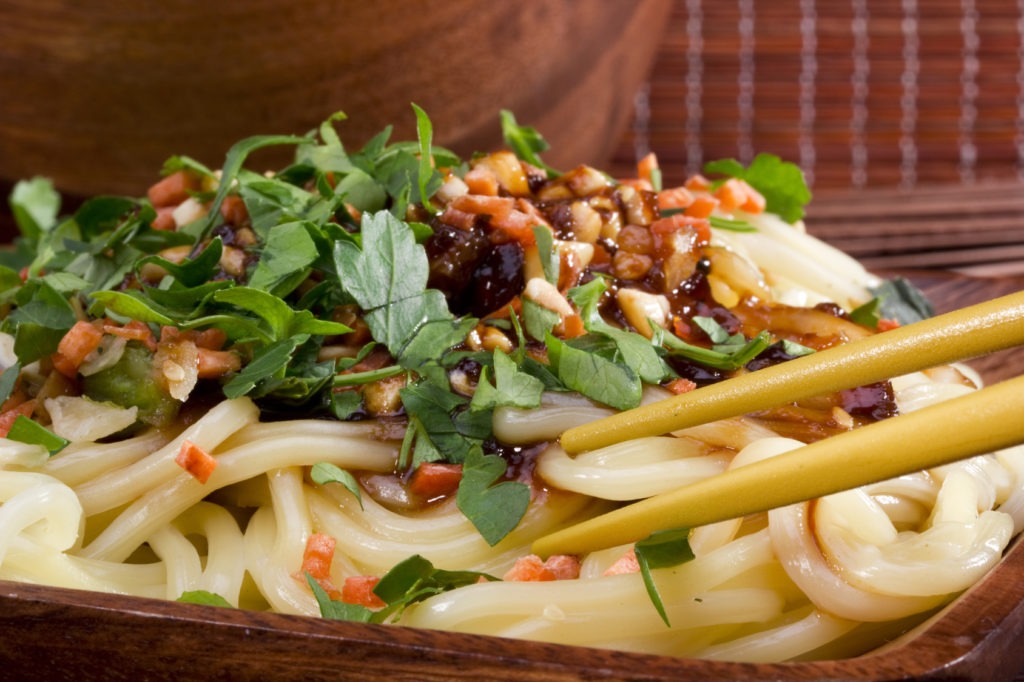 Noodle Month with Asian noodles on a brown wooden plate