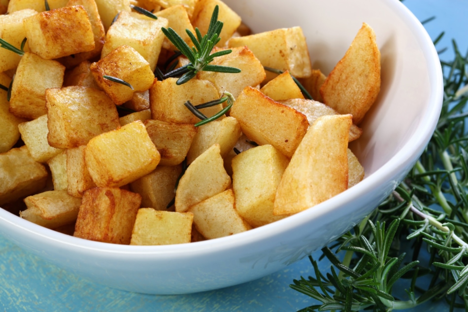 A bowl full of rosemary roasted potatoes ready to server