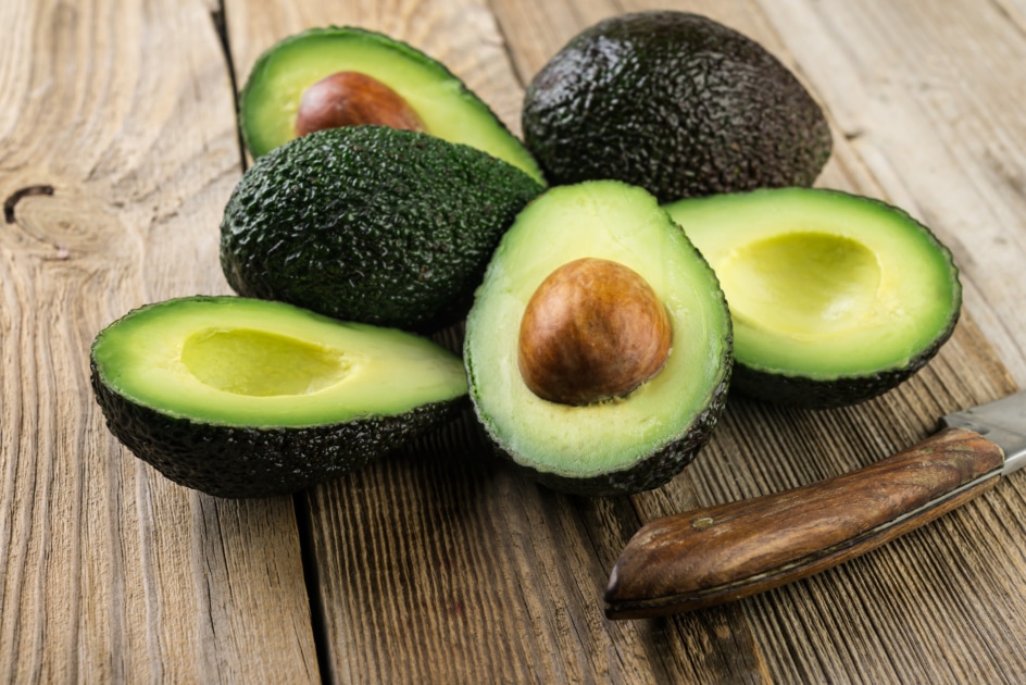 Fresh sliced avocado on wooden table.