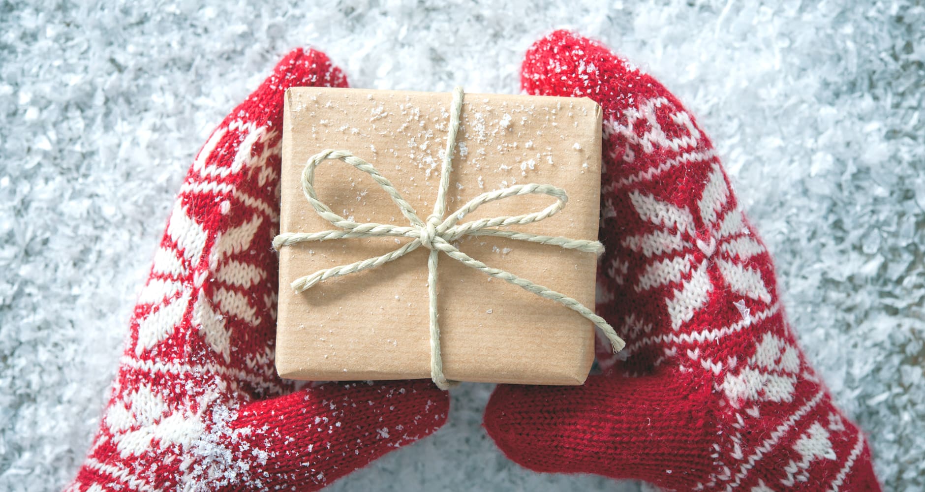 A British Boxing Day high street, a row of small wrapped gift boxes on a doorstep, snowy rooftops in the background.