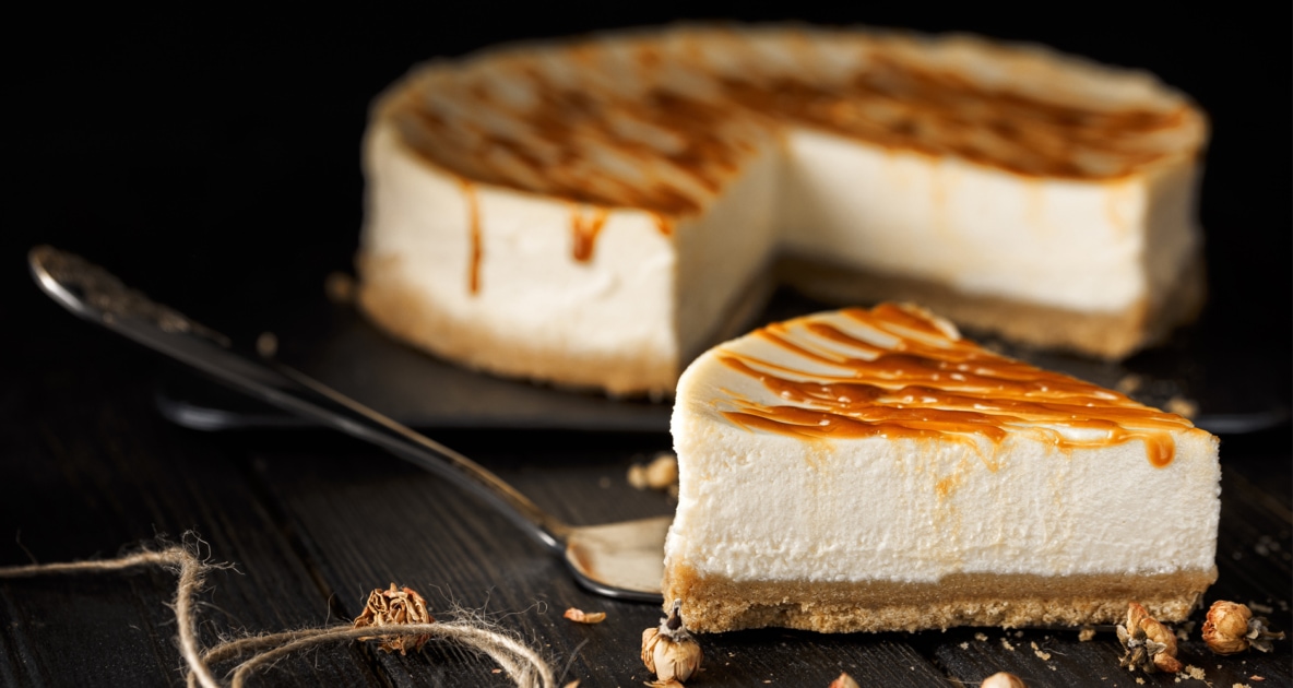 Slice of cheesecake cut away with caramel drizzling.