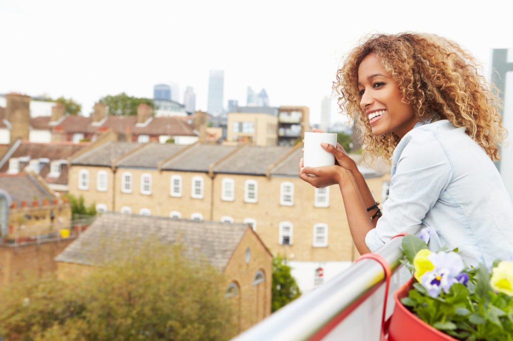 Woman Relaxing Outdoors On Rooftop Garden