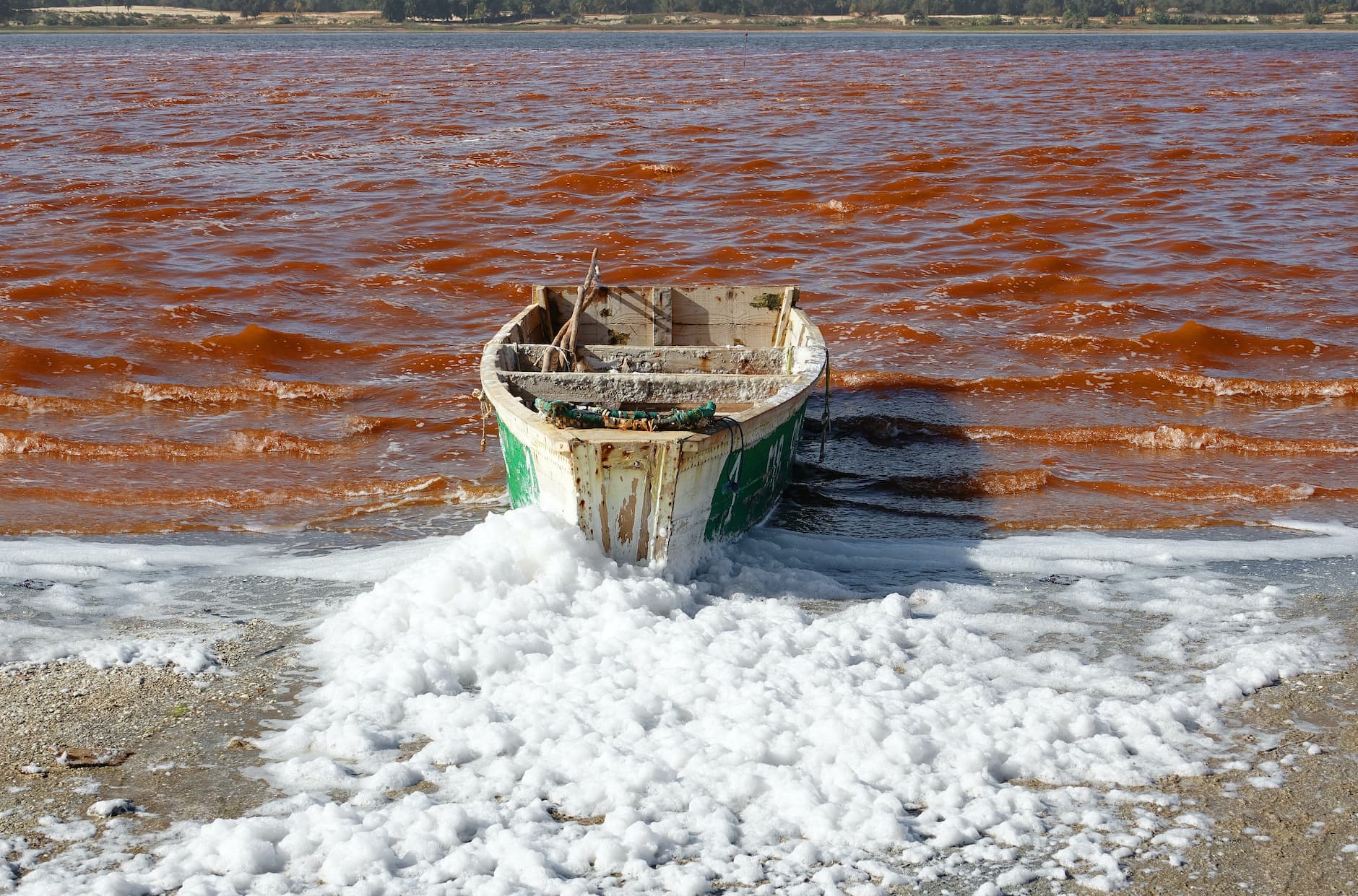 Fishing boat on Lake Retba red water