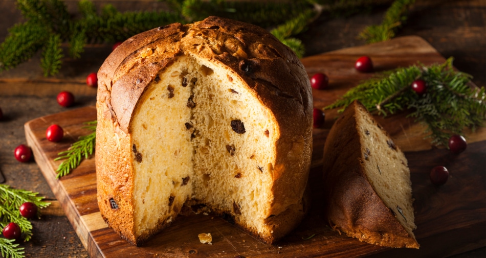 A panettone fruit cake adorned with Christmas decorations.