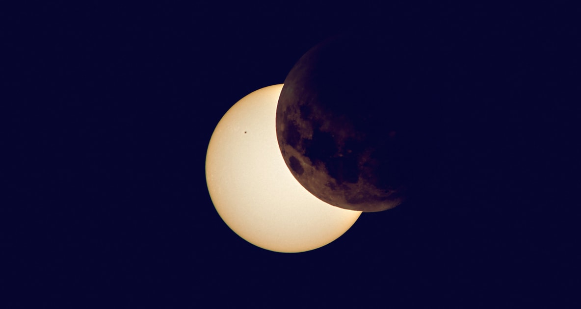 Solar eclipse with moon partially blocking out sun.