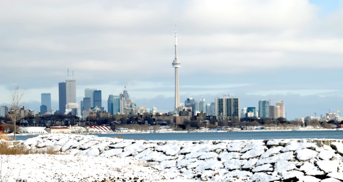 Cityscape of Toronto behind a lake during the winter.