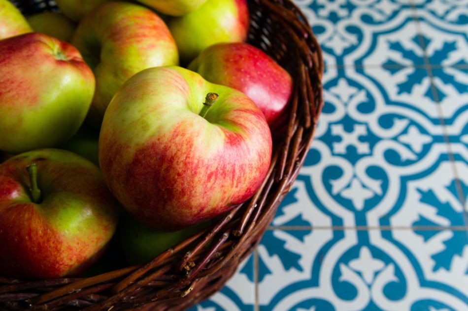 Basket of apples on tile