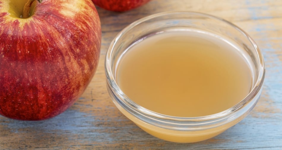 Apple Cider Vinegar in a bowl next to an apple