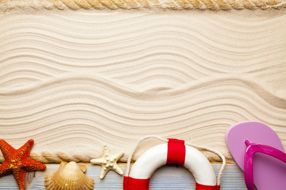 Beach vacation - flaps, lifebuoy and shells on sand.