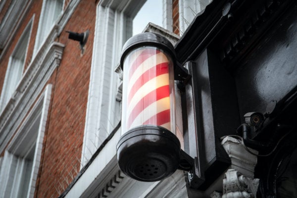 A barber's pole of red and white on the side of a building