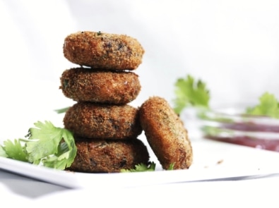 A stack of black bean burgers in a white dish.