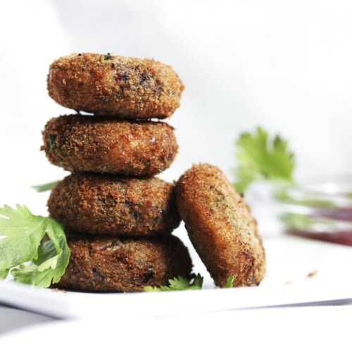 A stack of black bean burgers in a white dish.