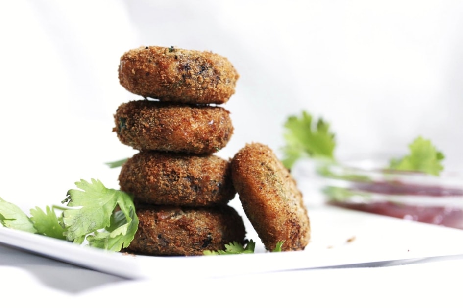 A stack of black bean burgers in a white dish.