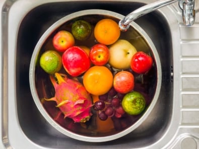 Fruits in a pot filled with water being cleaned.