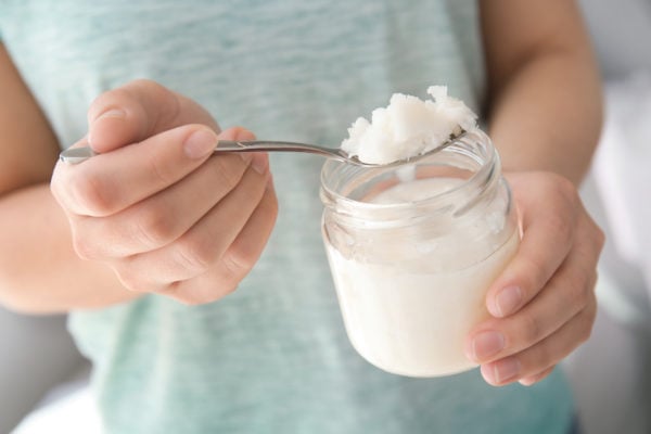 scooping coconut oil our of jar with spoon