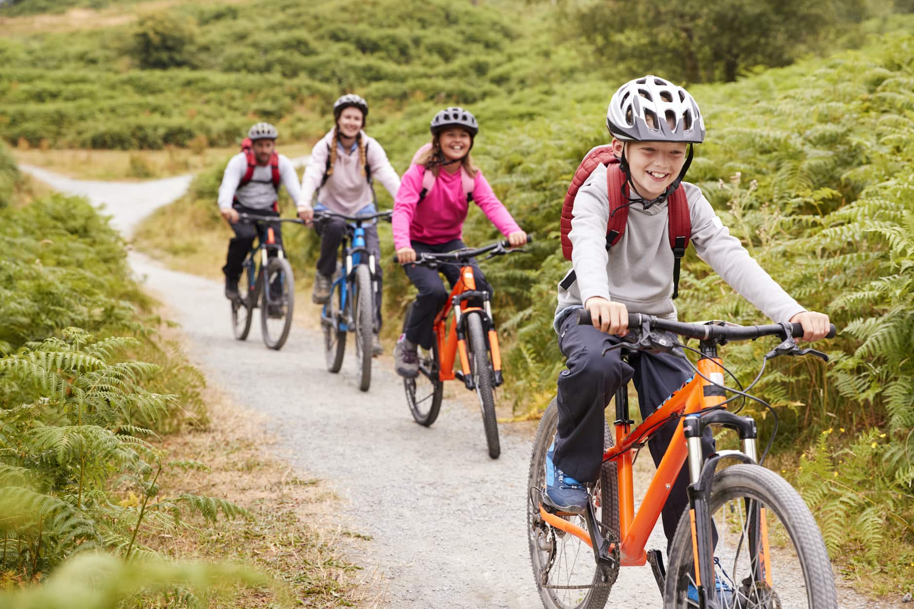Family in long sleeves on a wooded bike ride during black fly season