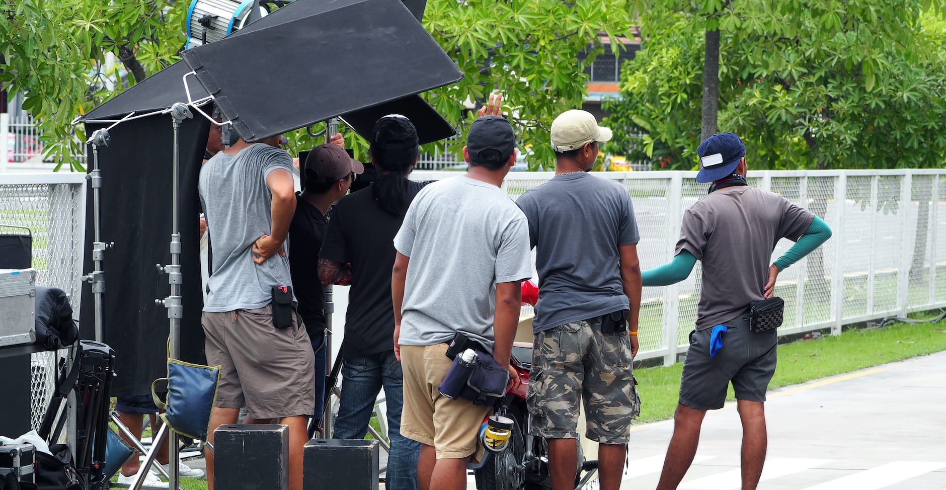 People filming on location in neighborhood.