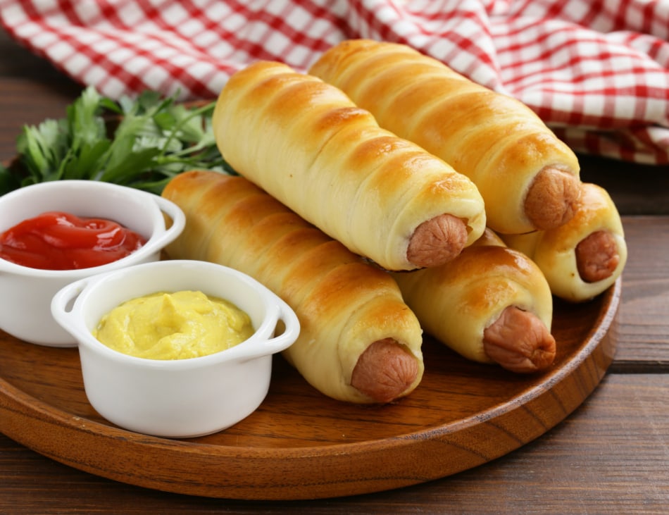 Hot dogs baked in dough are called pigs in a blanket.